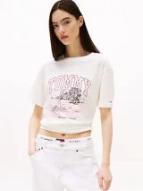 Remera blanca de algodón, corte amplio, con cuello redondo y mangas cortas. Estampado frontal con el logo "Tommy" y un paisaje tropical.