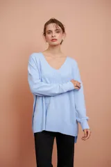 Sweater celeste de tejido de punto, con escote en V y corte asimétrico más largo en la parte trasera.