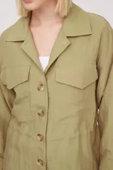 Chaqueta de corte ancho color verde oliva, con botones frontales y bolsillos en el pecho.