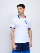 Remera polo blanca de poliéster con cuello clásico y mangas cortas con ribetes azules y rojos. Presenta el escudo del Club Nacional de Football bordado en el pecho.