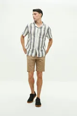 Camisa de manga corta confeccionada en lino y algodón a rayas verticales en tonos blanco, gris y beige. Tiene cuello tipo cubano, corte regular y logo bordado en el pecho.