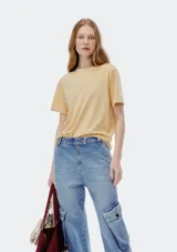 Remera color beige de corte clásico, con cuello redondo y mangas cortas.