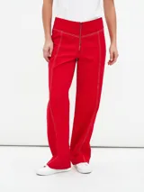 Pantalón rojo de corte recto con cierre frontal y costuras a la vista.