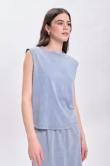 Camiseta celeste con cuello redondo y sisas anchas con hombreras marcadas.