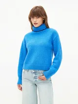 Sweater azul de punto con cuello alto y textura en relieve.