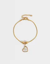 Pulsera dorada de acero inoxidable con dije de corazón de nácar y cadena extensible.