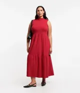Vestido midi de algodón rojo, con cuello alto, sin mangas y volados en el bajo.