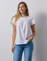 Blusa blanca de tejido pointelle con manga corta con volados y cuello redondo.