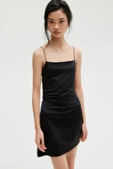 Vestido corto negro de breteles finos, escote cuadrado, corte ajustado y frunces laterales que generan un efecto drapeado en la falda.