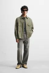 Sobrecamisa verde militar de algodón con estructura canvas, corte relaxed fit, cuello solapa, manga larga con puños abotonados, bolsillos frontales de plastrón con solapa, efecto lavado y cierre frontal con botones.