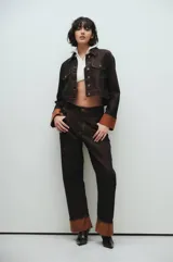 Campera de jean cropped color marrón oscuro, con costuras en contraste color beige, bolsillos con solapa, botones metálicos y puños rebatidos color marrón claro.