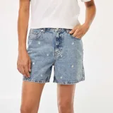 Short de jean celeste con bordados de flores blancas.