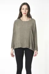Camiseta manga larga color verde oliva con cuello redondo desbocado y efecto desgastado. Confeccionada en una sola pieza, sin sisa, generando un volumen especial en la manga.