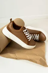 Zapatillas de estilo casual con estampado de animal print en tonos marrón y negro.