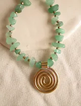 Collar con piedras semipreciosas en tonos verdes y colgante de bronce con diseño en espiral.