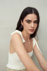 Top tejido blanco con tiras para anudar en los hombros y diseño tramado. Silueta ajustada y textura acanalada.