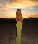 Conjunto verde de top halter con escote profundo y falda midi ajustada.