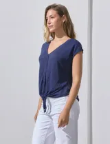 Blusa de modal con estampado de hojas en tonos azulados, escote en V con botones y ruedo anudado.