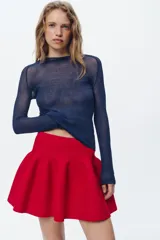 Falda mini roja de punto con cintura elástica y corte evasé.