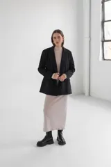 Blazer gris de corte clásico con solapas de muesca, cierre frontal con dos botones y bolsillos laterales con solapa.