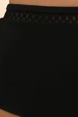 Calzón de bikini negro de tiro alto con detalle de calado geométrico en la cintura.