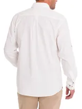 Camisa blanca de manga larga para hombre, confeccionada en algodón orgánico. Cuenta con cuello camisero, cierre con botones de madera, bolsillo en el pecho y mangas ajustables con botones.