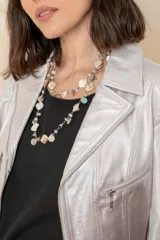 Chaqueta corta de cuero ecológico con diseño degradado de blanco a gris. Tiene cuello tipo solapa, cierre frontal asimétrico con broche y bolsillos con cierre.