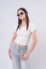 Remera blanca de manga corta, corte ajustado y escote redondo. Presenta un pequeño detalle de etiqueta negra en la manga izquierda.