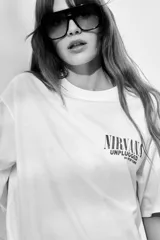 Remera blanca de corte amplio con cuello redondo y mangas cortas. Estampado frontal con el logo de Nirvana y la leyenda "Unplugged in New York".