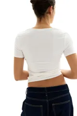 Remera blanca de punto suave con escote cuadrado y mangas cortas.