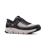 Championes deportivos Skechers Hands Free Slip-ins Summits AT, color negro con detalles en beige. Diseñados con tecnología Heel Pillow, capellada de malla resistente y revestimiento sintético con cordones ajustables.