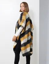 Ruana de tejido soft, color rosa pálido, celeste, gris y beige, con diseño a cuadros. Presenta terminación en zig zag con lana en los bordes y sisa amplia.