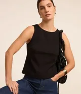 Blusa negra sin mangas confeccionada en crepé con cuello redondo y abotonado delantero.