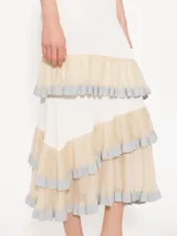 Falda midi de color blanco con paneles horizontales en beige y volados con borde plateado.