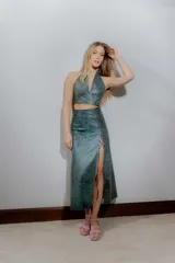 Falda midi de cuero ovino color verde azulado con efecto desgastado. Presenta tajo lateral con cordones cruzados.