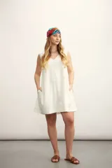 Vestido corto color negro, sin mangas, con escote en V y bolsillos laterales.