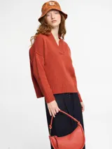 Sweater de tejido de punto color marrón, con escote en v y mangas de sisa caída.