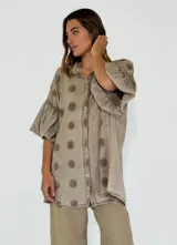 Camisa color lila con textura de lunares en relieve, de corte holgado, manga 3/4 con volados y cierre frontal con botones.