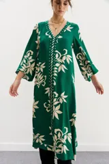 Vestido midi verde con estampado de hojas color crema, escote en V y mangas 3/4 amplias.