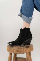 Bota corta de cuero gamuzado color negro, con punta fina y diseño bordado estilo western. Tiene un pequeño tirador en la parte trasera y un taco cónico de altura media.