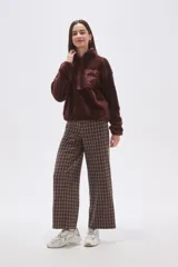 Buzo de polar tipo sherpa en color crudo, con cuello alto y cierre frontal parcial. Presenta un bolsillo de parche con cierre en el pecho y mangas largas de calce holgado.