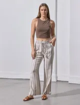 Pantalón de lino color beige con rayas verticales marrones, pretina ancha con punto smock y lazo ajustable, bolsillos verticales delanteros y bolsillos aplicados traseros.