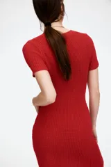 Vestido corto de punto color rojo, de corte ajustado, manga corta y cuello redondo.