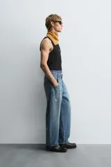 Musculosa blanca de algodón con cuello redondo y sisas amplias, corte ajustado.