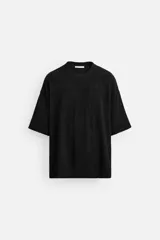 Sudadera negra de tejido texturizado con mezcla de algodón. Corte relaxed fit, cuello redondo y manga corta.