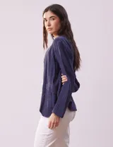 Chaqueta azul de algodón con bolsillos simulados y terminación desflecada.
