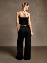 Pantalón negro de corte ancho con pinzas en la cintura.