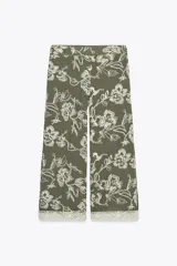 Pantalón de tiro alto color verde oliva con bordado floral blanco, bolsillos laterales ocultos, pernera ancha y terminación en guipur.