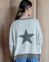 Buzo tostado de corte holgado con cuello redondo y manga larga. Presenta una estrella blanca estampada en la espalda y ribete marrón en cuello y ruedo.