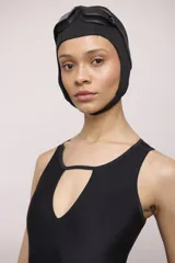 Malla de una pieza color negro, con escote redondo y abertura en forma de lágrima en el centro del busto. Presenta tirantes anchos y corte clásico en la pierna.